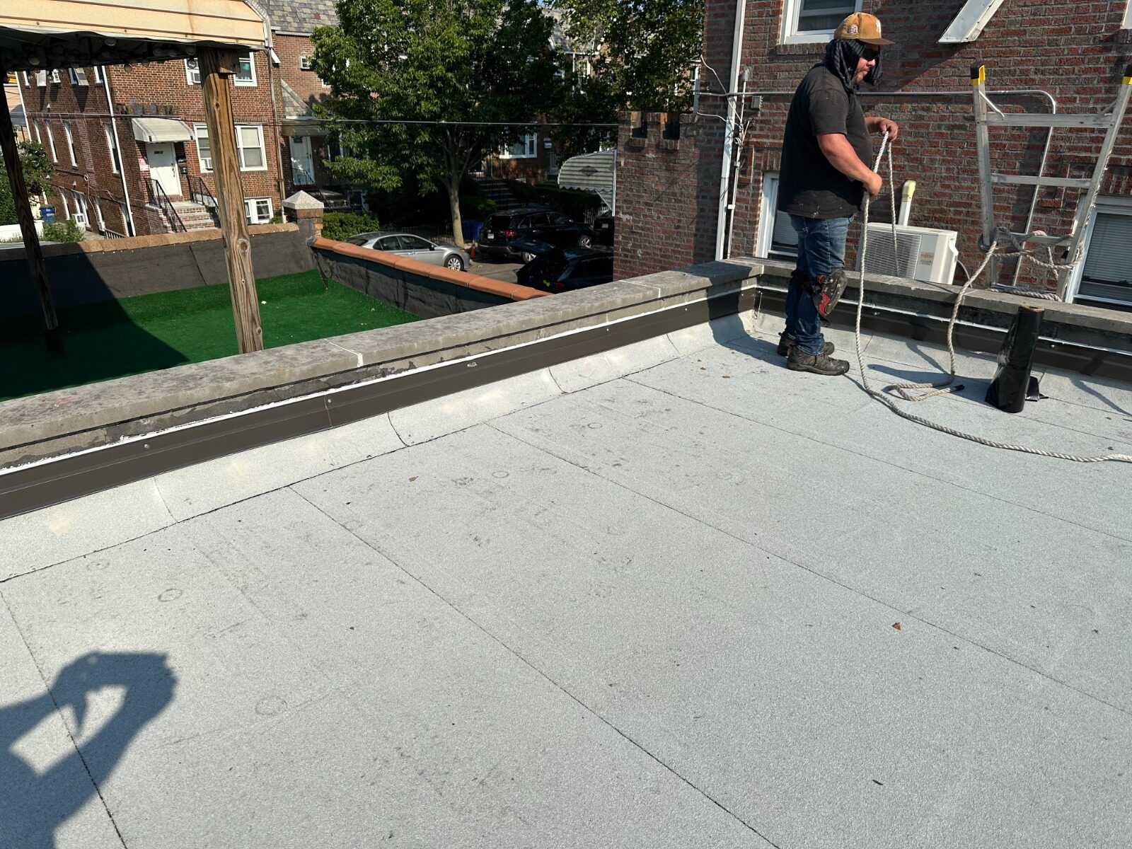 Roofing crew finishing flat roof installation - Queens NY