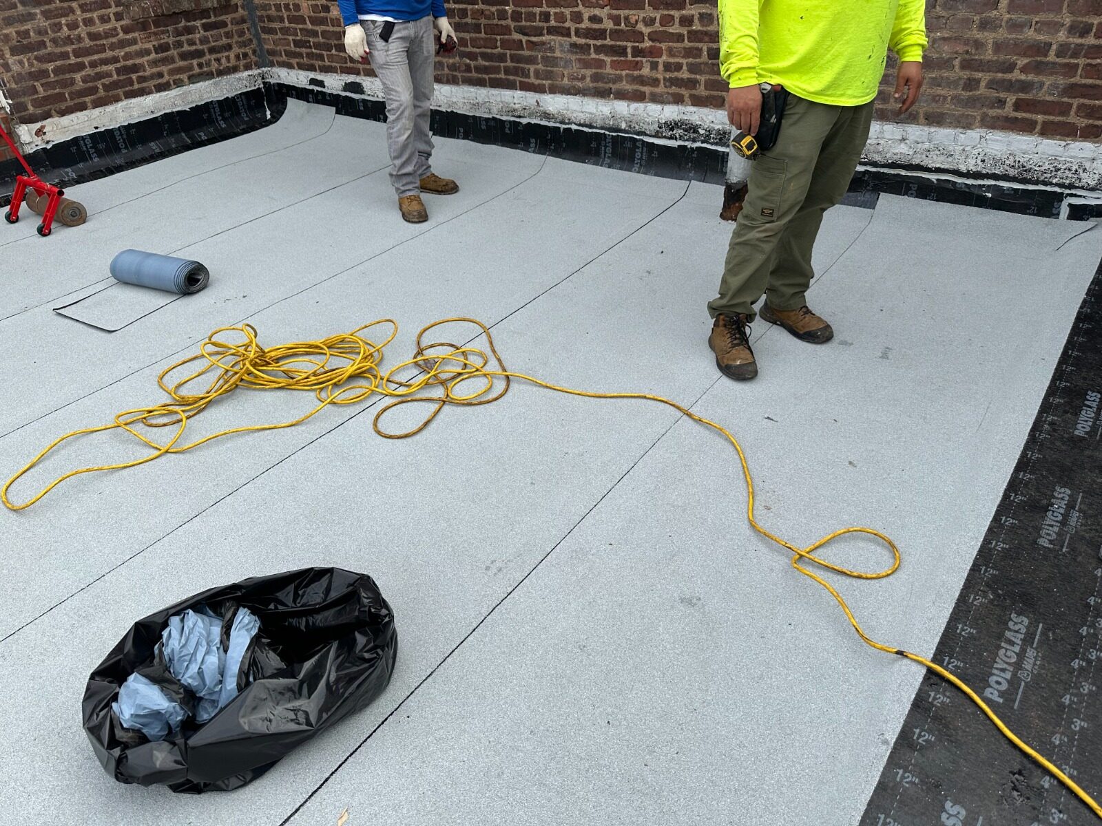 Roofing crew installing new membrane - Five Boroughs